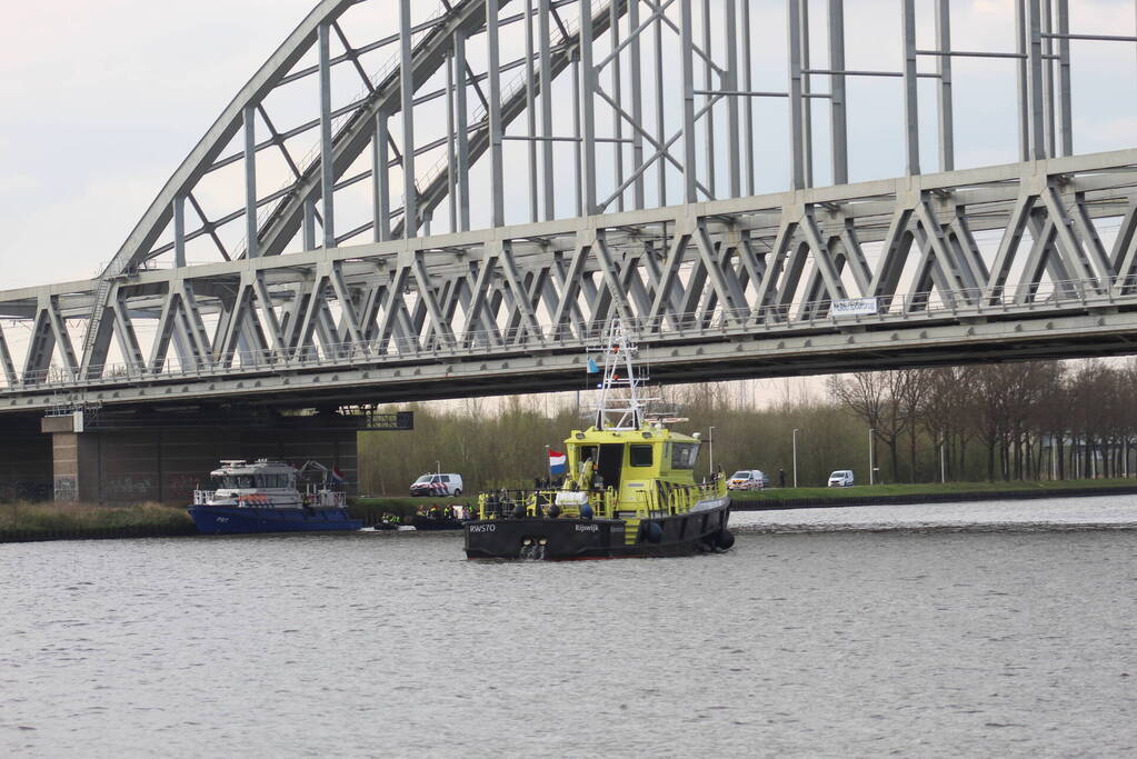 Persoon op bogen van brug, vele hulpdiensten aanwezig