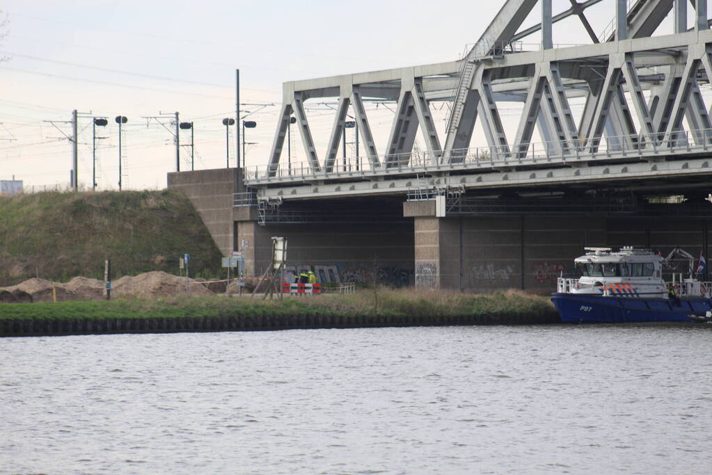 Persoon op bogen van brug, vele hulpdiensten aanwezig
