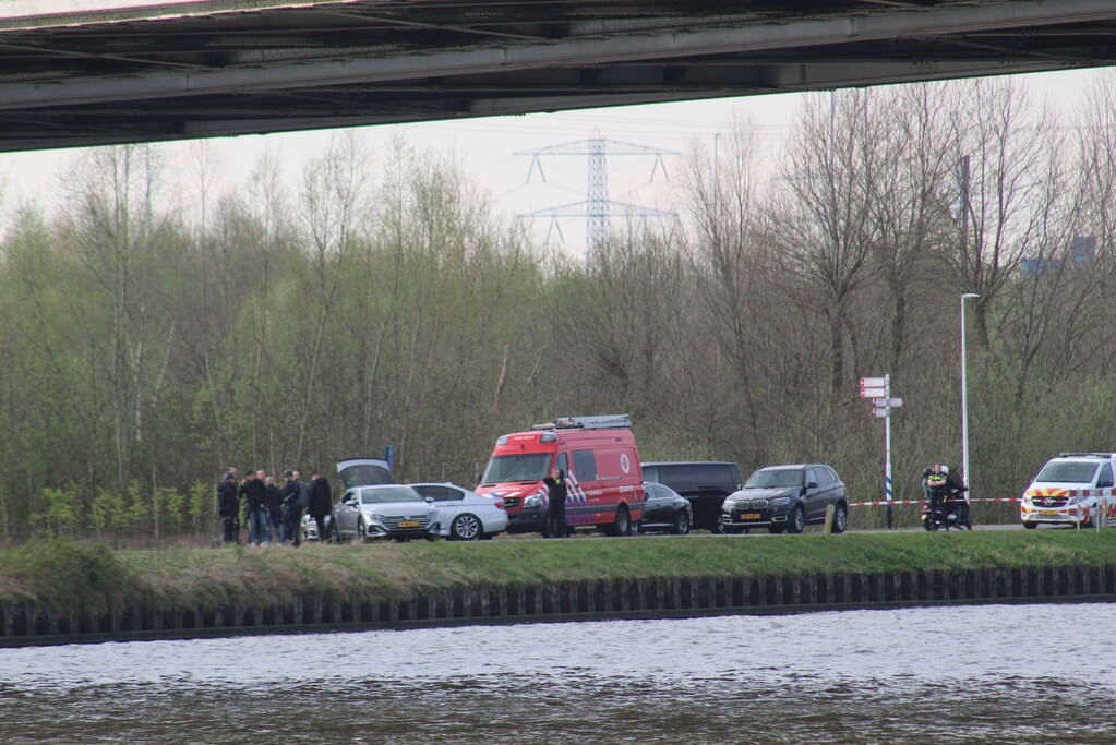 Persoon op bogen van brug, vele hulpdiensten aanwezig