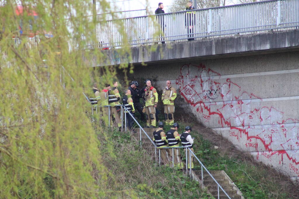 Persoon op bogen van brug, vele hulpdiensten aanwezig