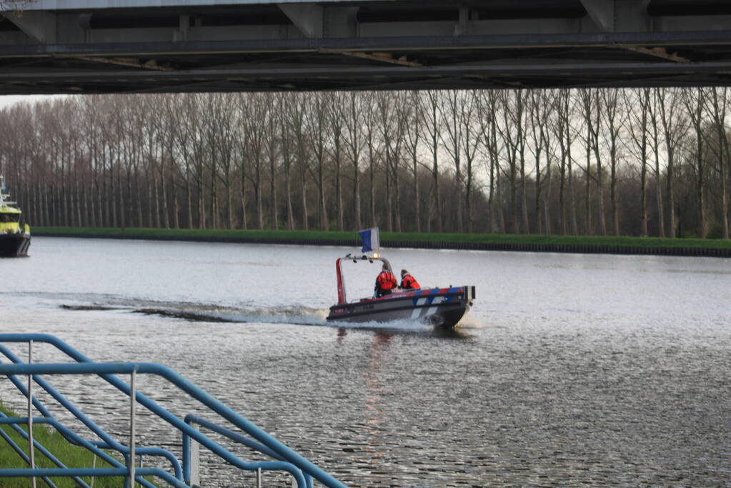 Persoon op bogen van brug, vele hulpdiensten aanwezig