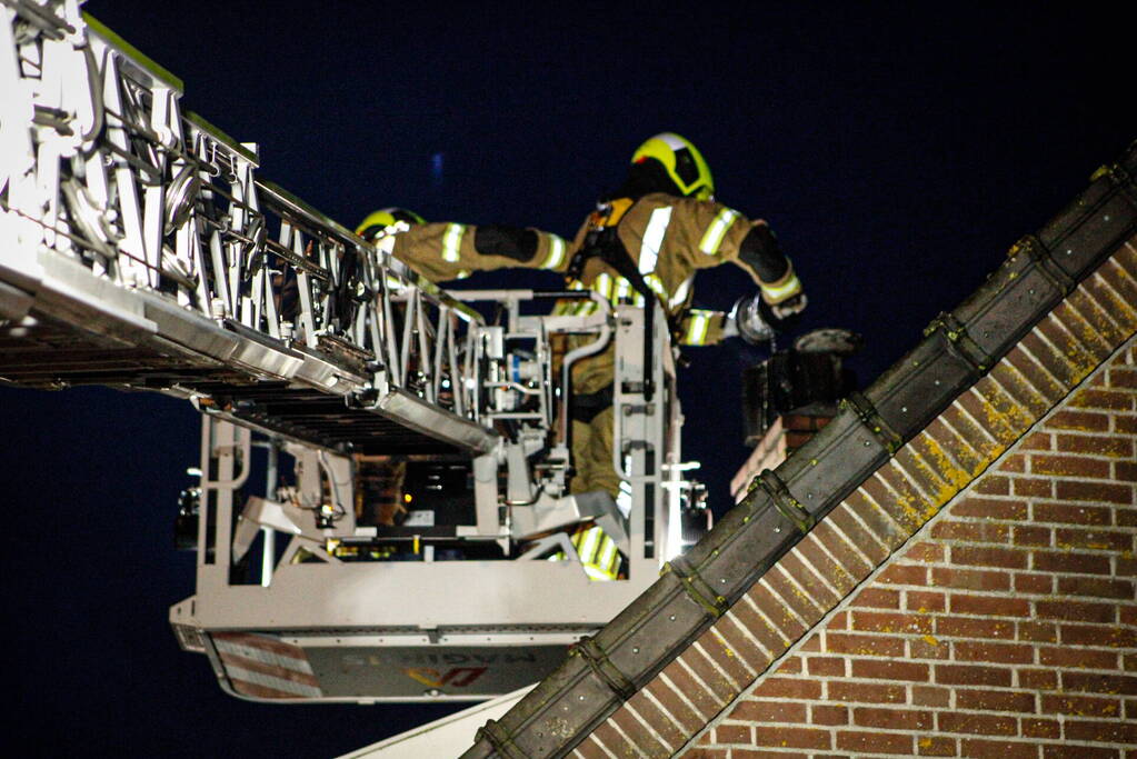 Brandweer veegt schoorsteen na brand