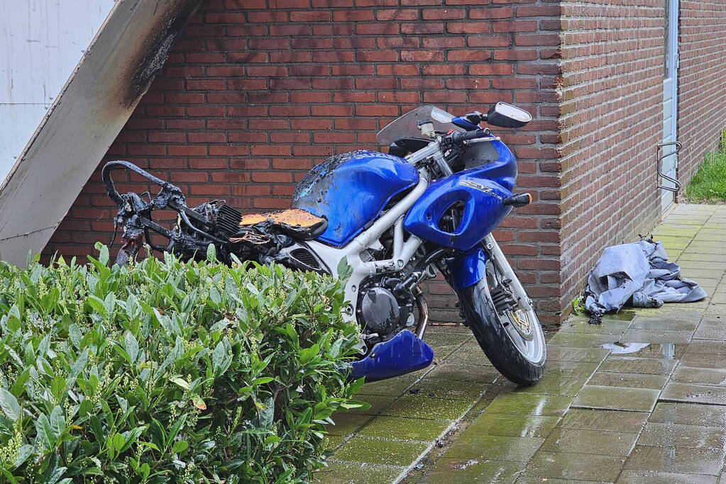 Motor in brand naast flatgebouw