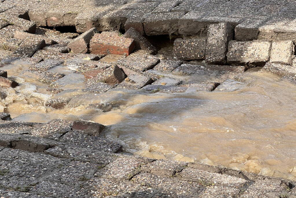 Wegdek verzakt door leidingbreuk