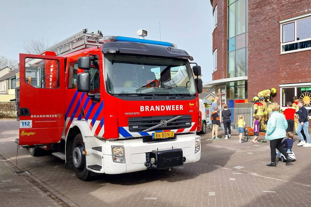 Kind bekneld tussen hek en betonnen container