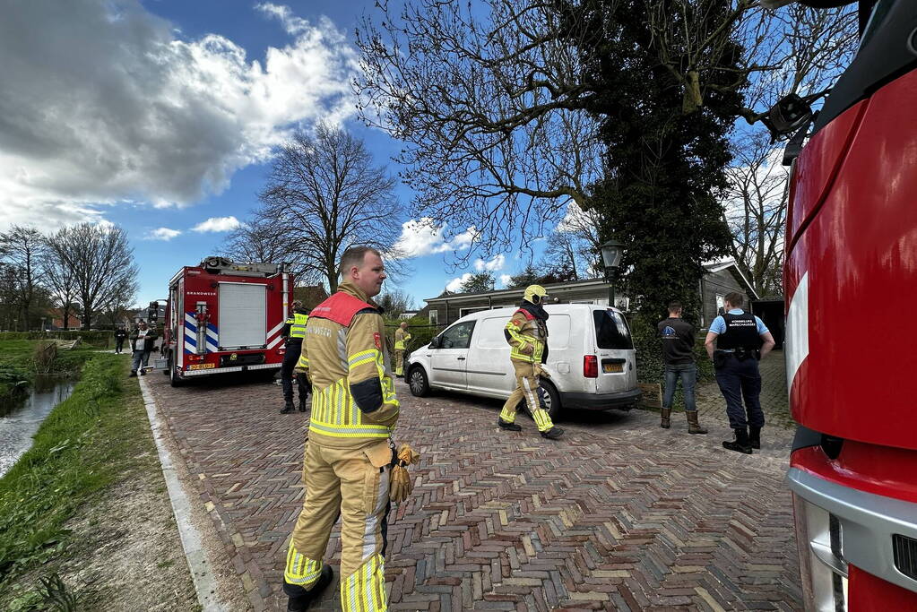 Brandweer blust brand achter woning