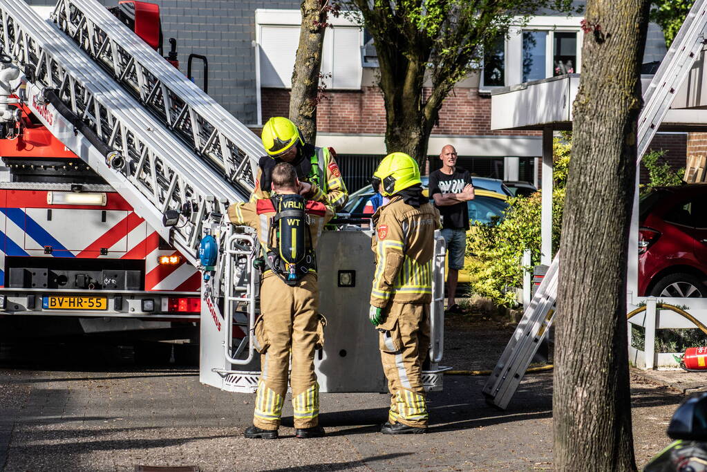 Brandweer breekt dak open om brand te bestrijden