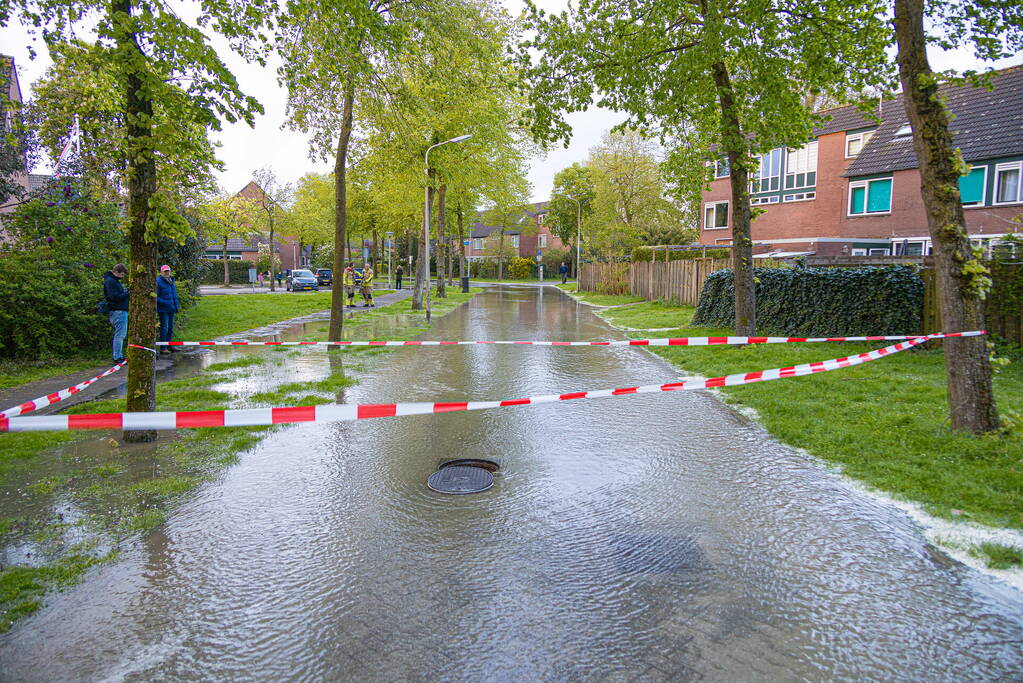 Straat onderwater door gesprongen leiding