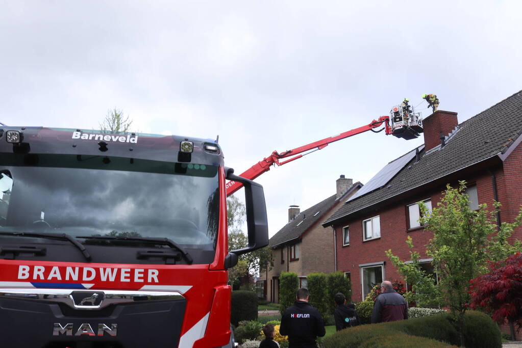 Vlammen slaan uit schoorsteen