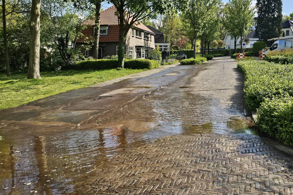 Straat onder water door leidingbreuk