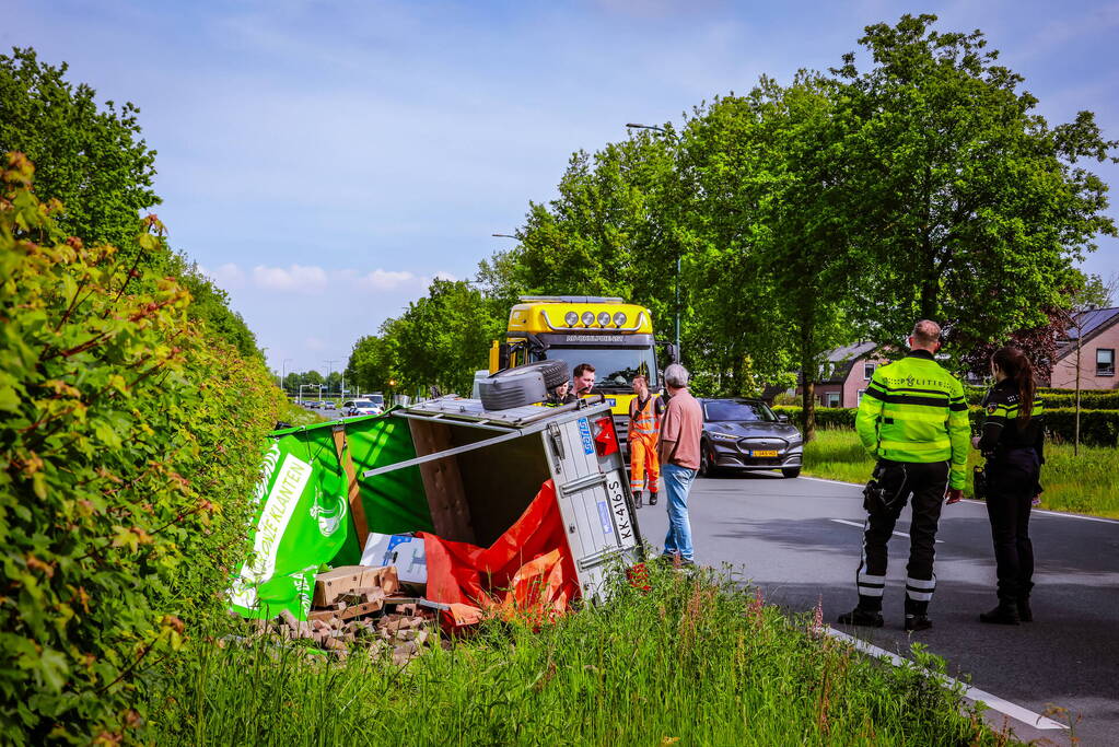 Aanhanger geladen met stenen belandt op zijn kant