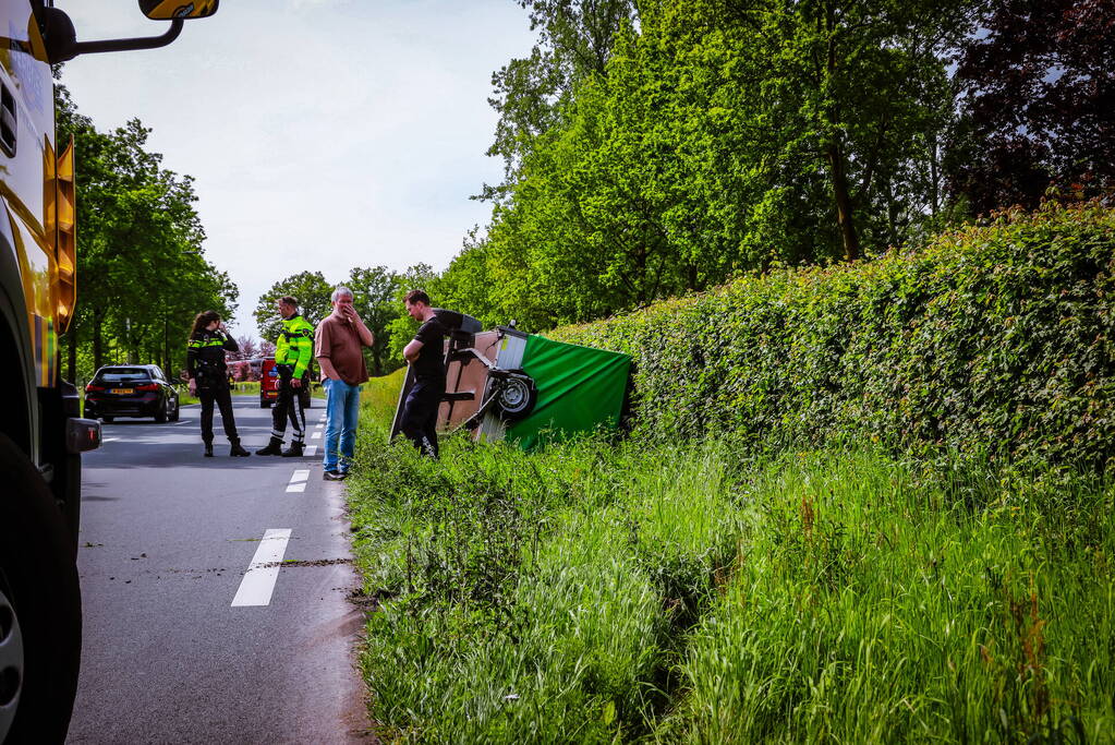 Aanhanger geladen met stenen belandt op zijn kant