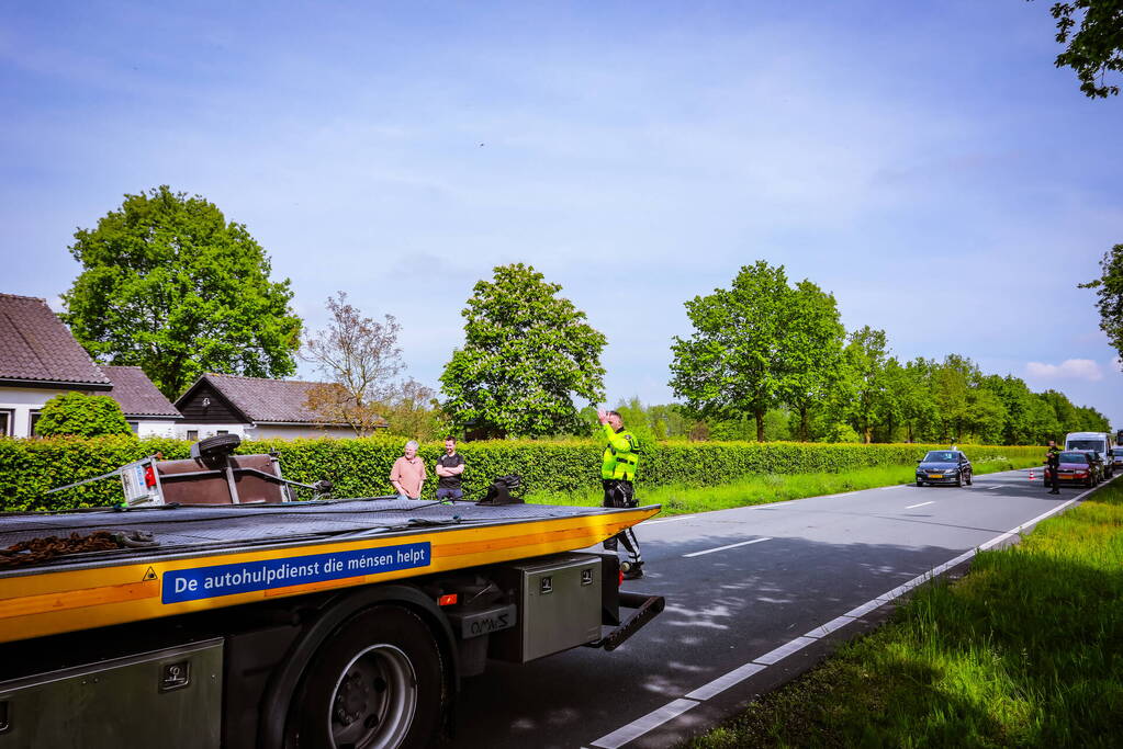 Aanhanger geladen met stenen belandt op zijn kant