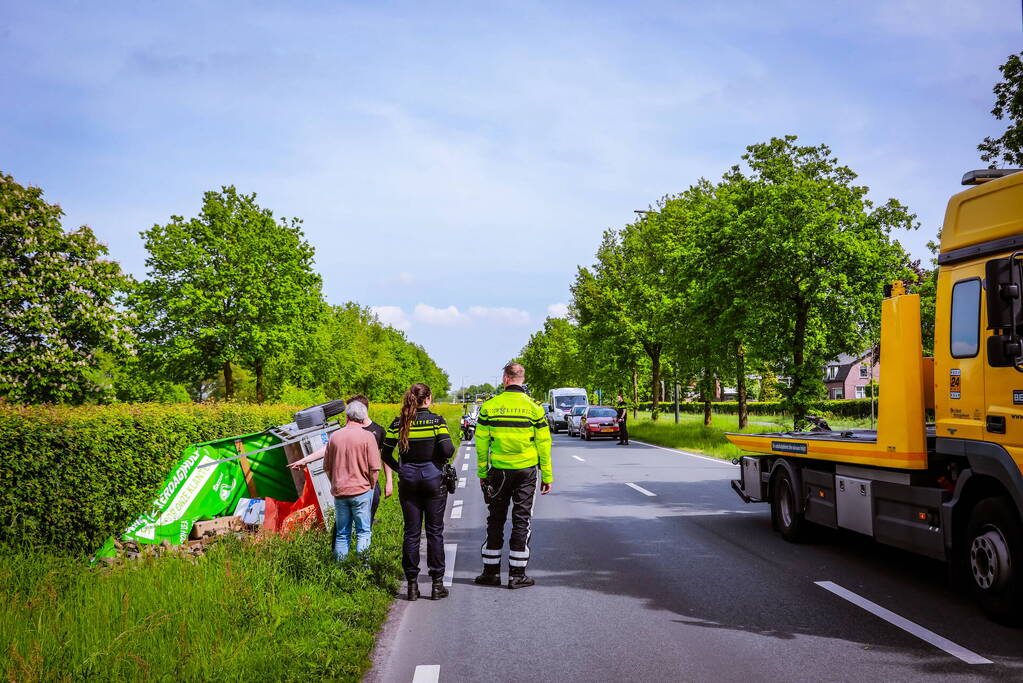 Aanhanger geladen met stenen belandt op zijn kant
