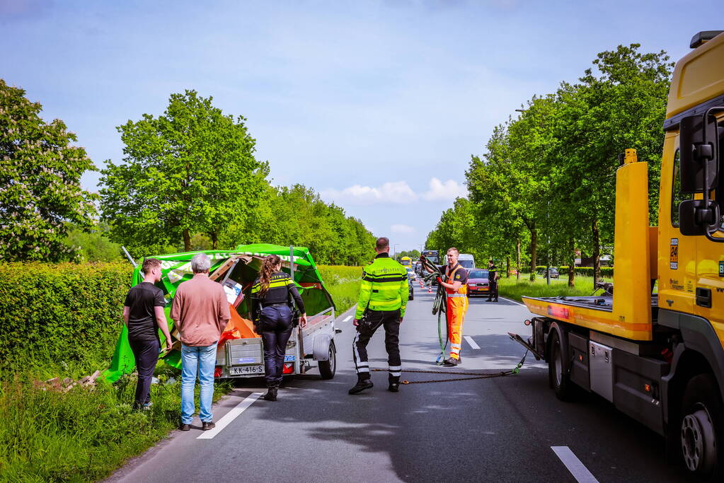 Aanhanger geladen met stenen belandt op zijn kant