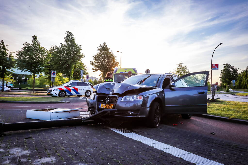 Automobilist vliegt over de rotonde botst op lantaarnpaal