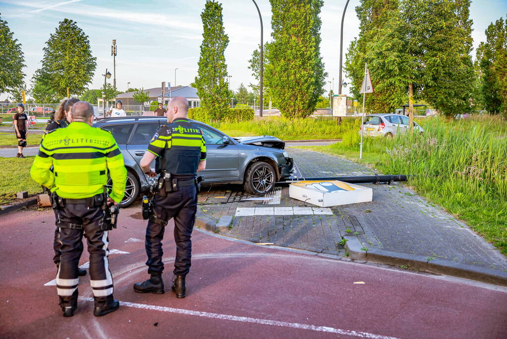 Automobilist vliegt over de rotonde botst op lantaarnpaal