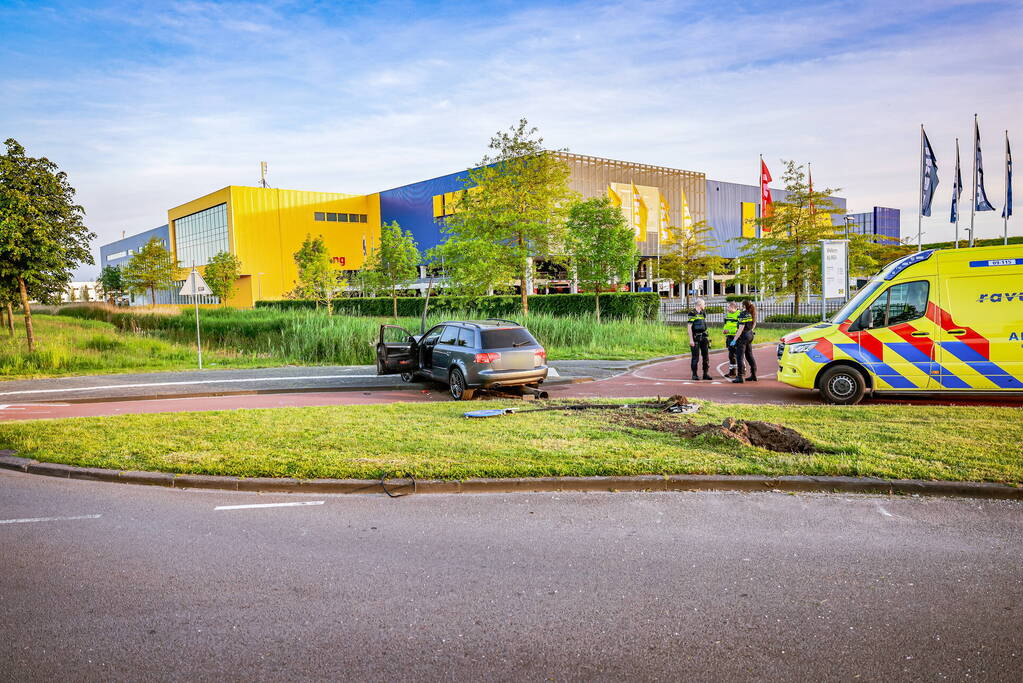 Automobilist vliegt over de rotonde botst op lantaarnpaal