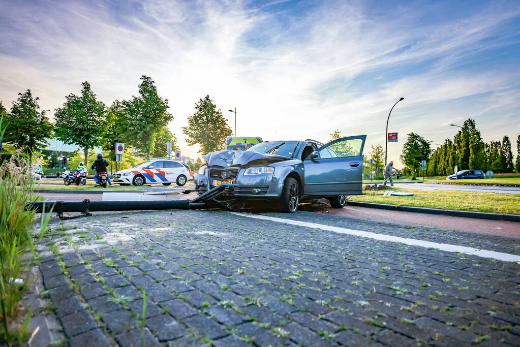 Automobilist vliegt over de rotonde botst op lantaarnpaal