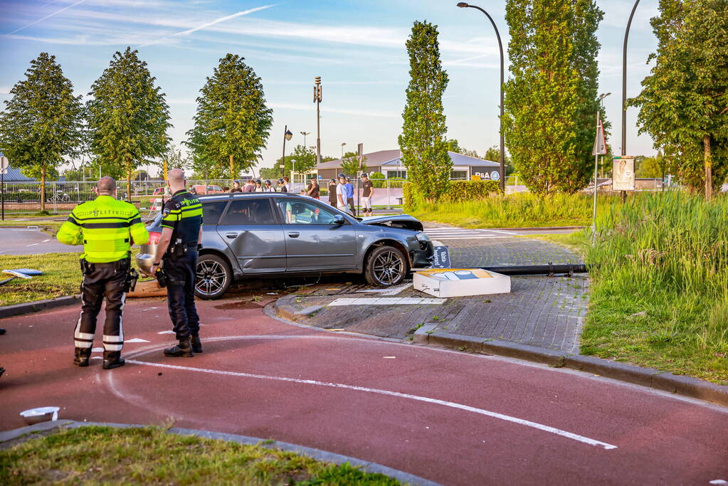 Automobilist vliegt over de rotonde botst op lantaarnpaal