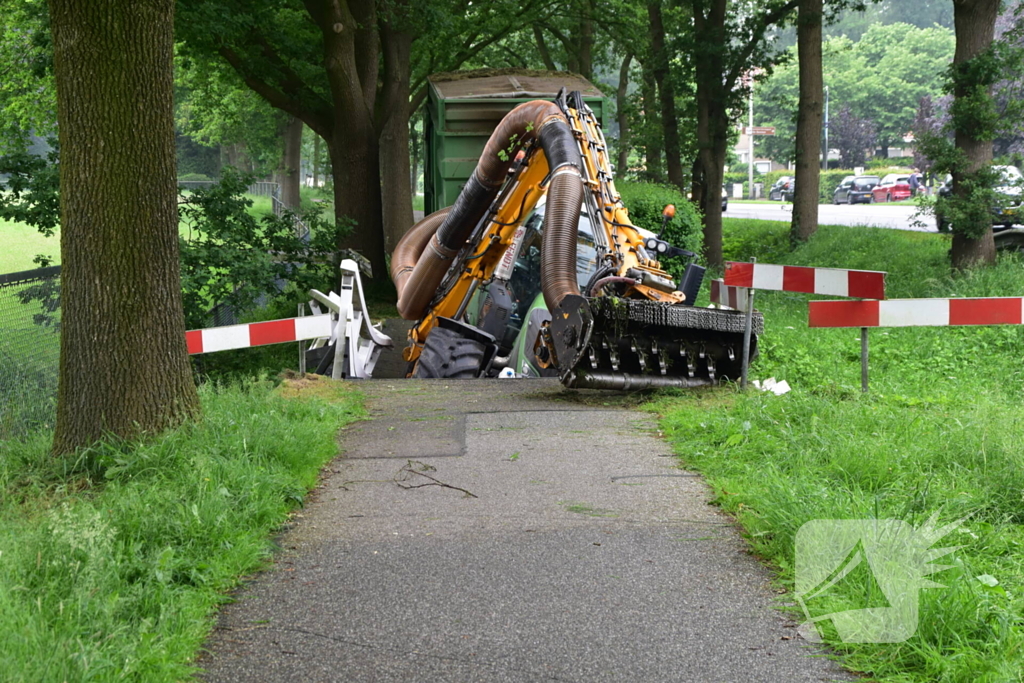 Berm maaier zakt door brug