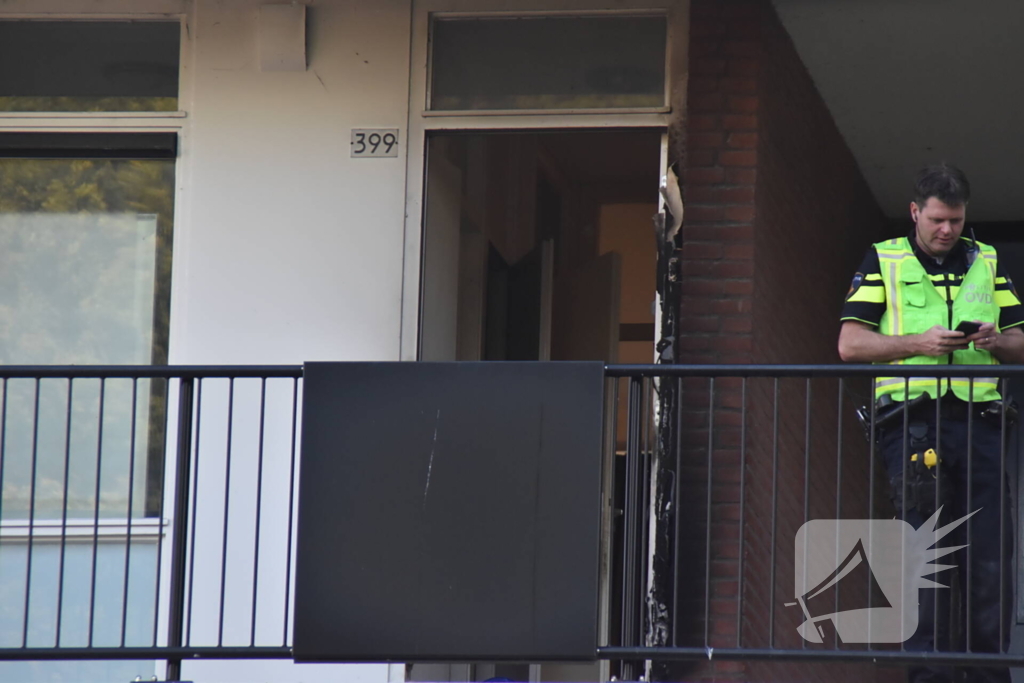 Afval voor voordeur in brand bewoner door brandweer naar buiten begeleidt