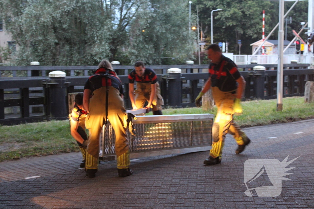Persoon onwel op peiler van brug, brandweer haalt hem eraf