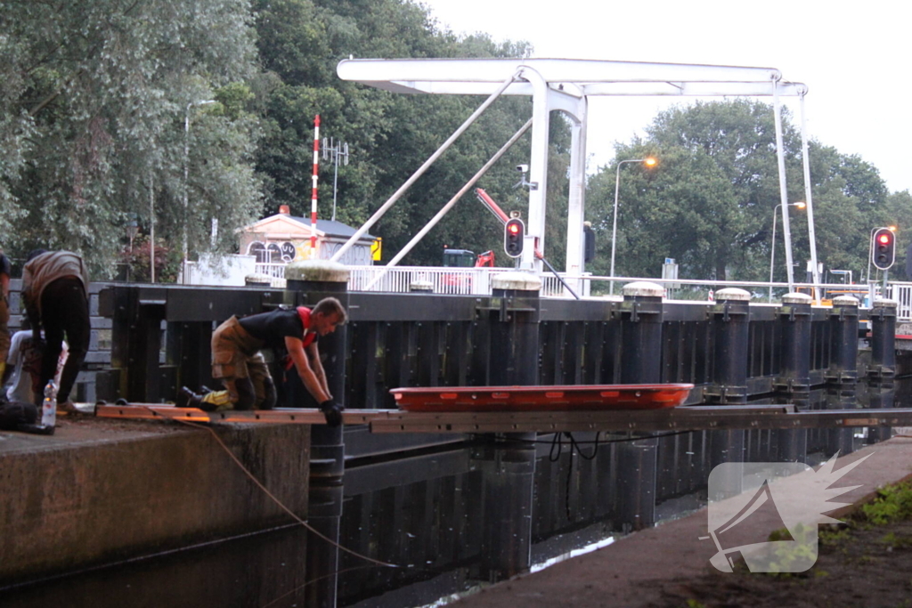 Persoon onwel op peiler van brug, brandweer haalt hem eraf