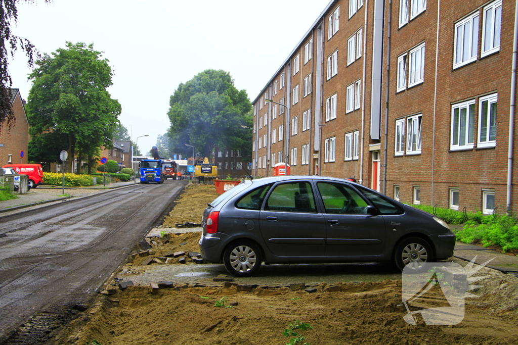 Asfalt om geparkeerde auto verwijderd