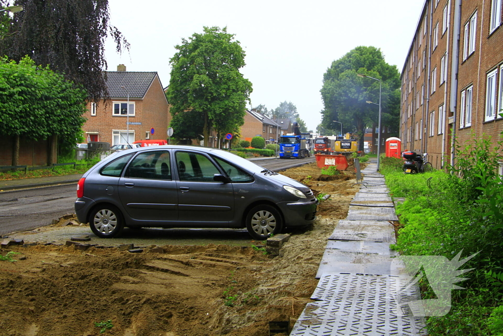Asfalt om geparkeerde auto verwijderd