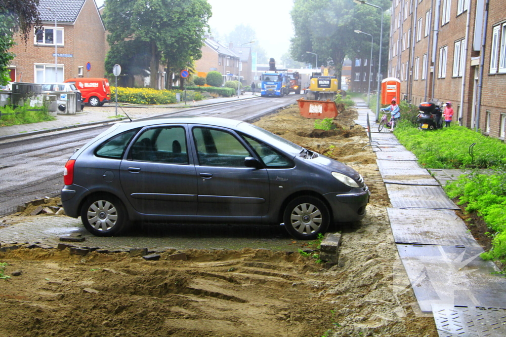 Asfalt om geparkeerde auto verwijderd