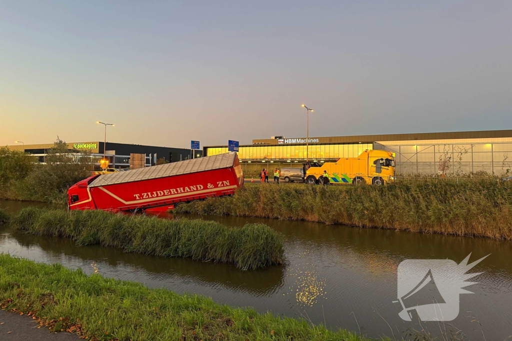Te water geraakte vrachtwagen geborgen door grote hijskranen
