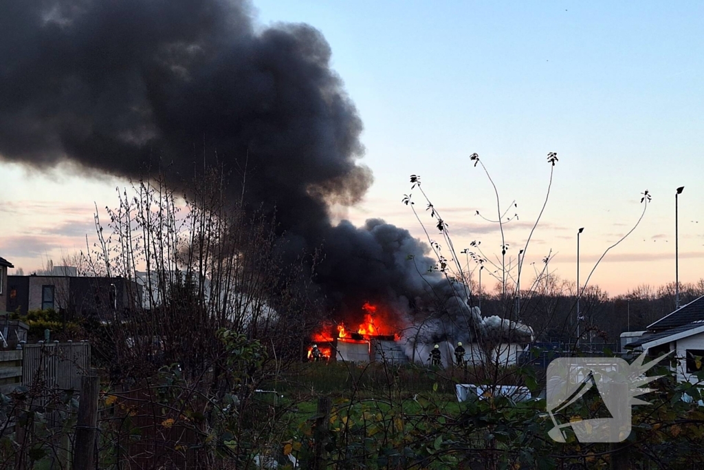 Brandweer trekt terug bij grote brand in garageboxen, instortingen door explosies