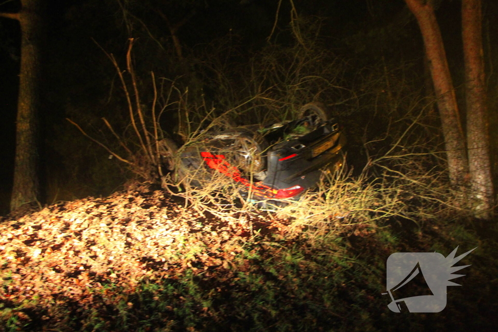 Auto vliegt uit beruchte bocht en belandt op de kop