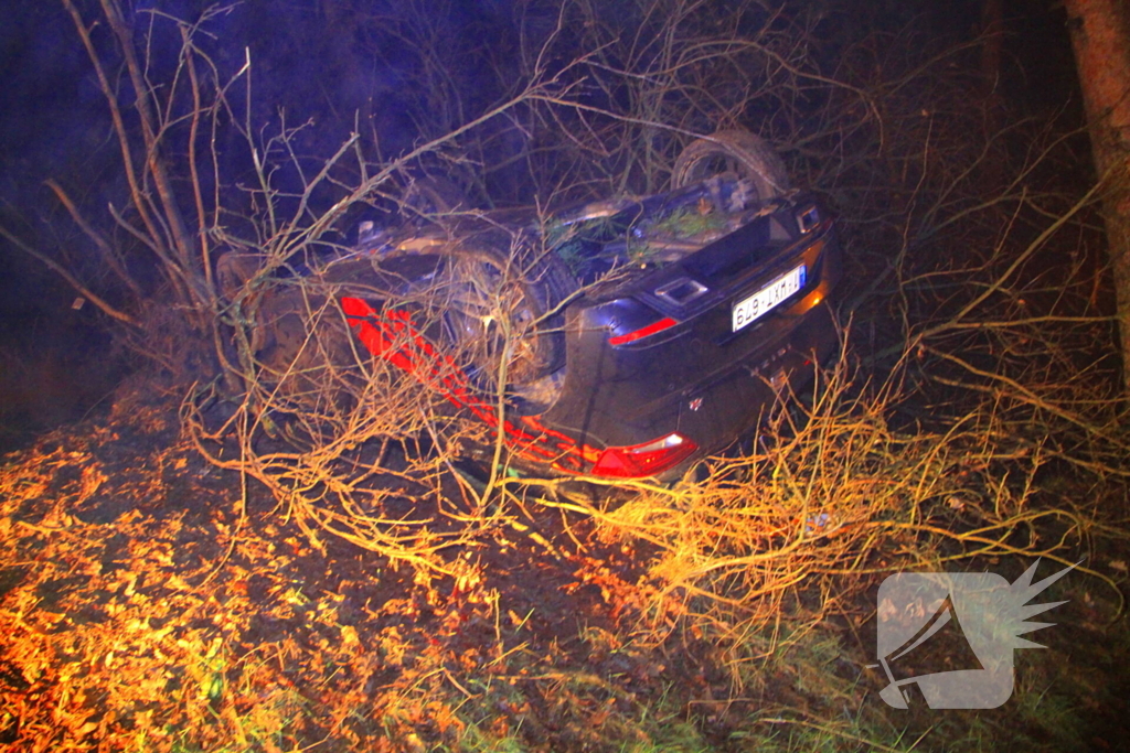 Auto vliegt uit beruchte bocht en belandt op de kop