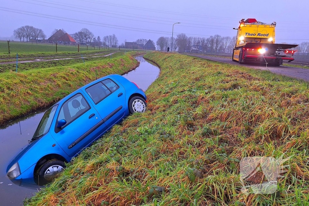 Auto te water door modderig wegdek