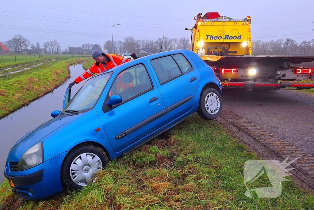 Auto te water door modderig wegdek
