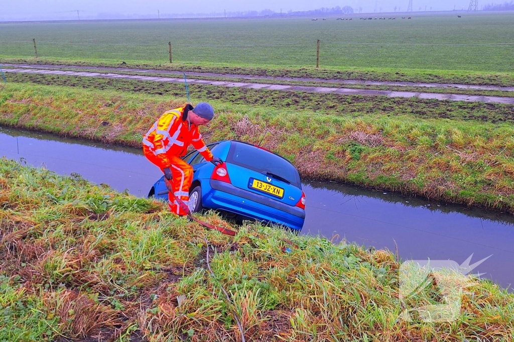 Auto te water door modderig wegdek