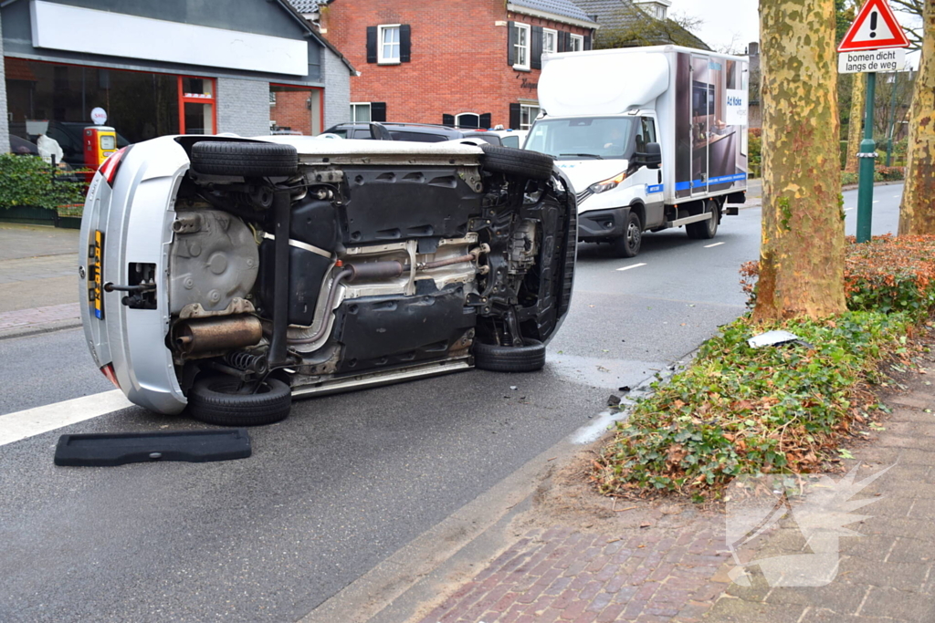 Bestuurster raakt boom, auto belandt op zijkant