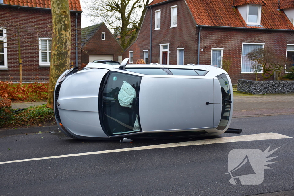 Bestuurster raakt boom, auto belandt op zijkant
