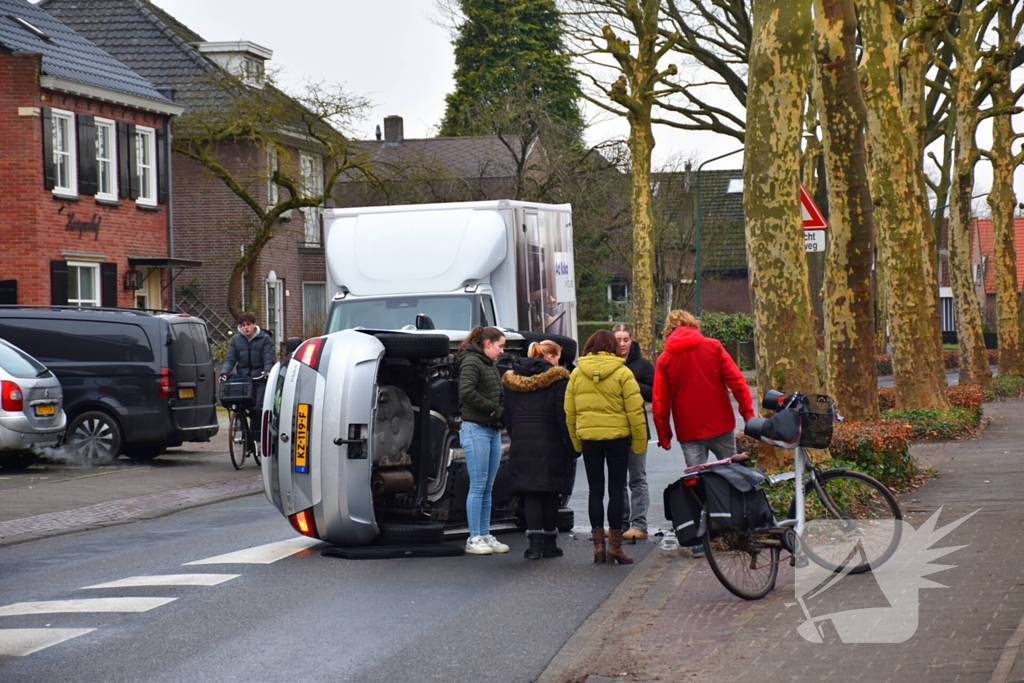 Bestuurster raakt boom, auto belandt op zijkant