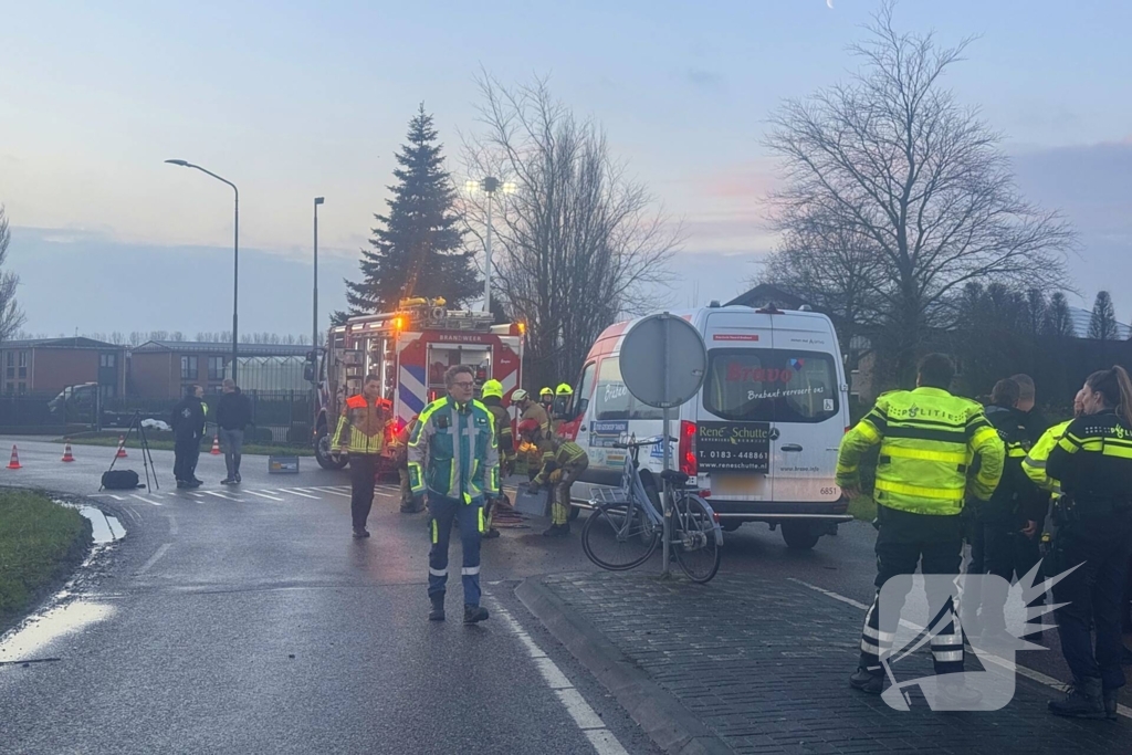 Fietser vast onder buurtbus