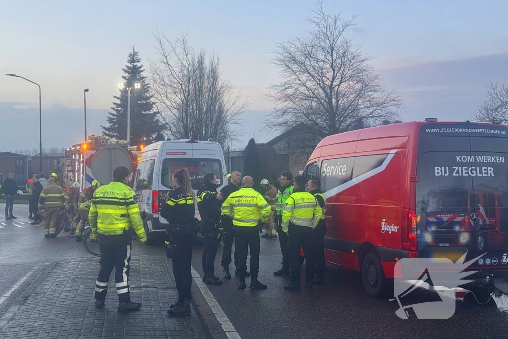Fietser vast onder buurtbus