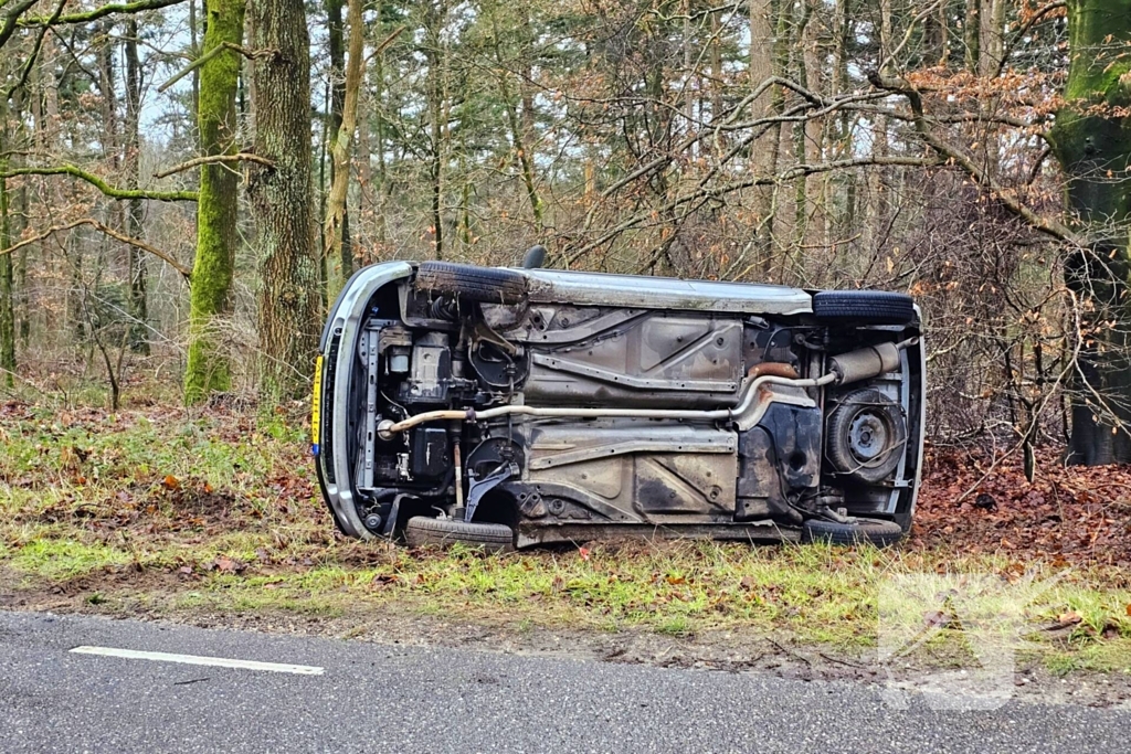 Auto belandt op zijkant naast weg