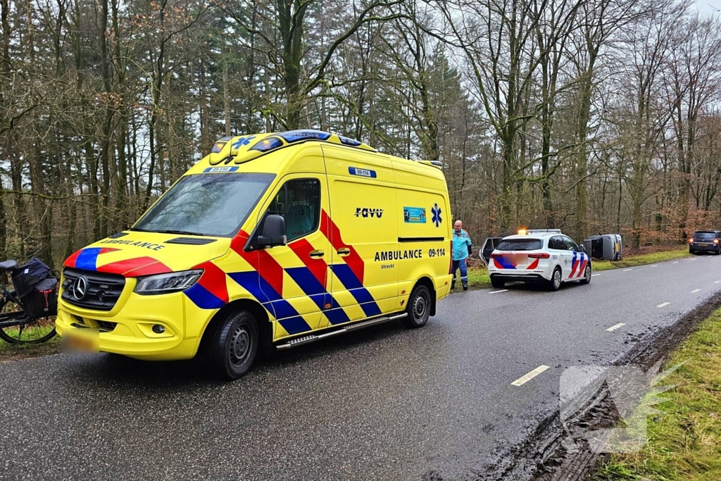 Auto belandt op zijkant naast weg