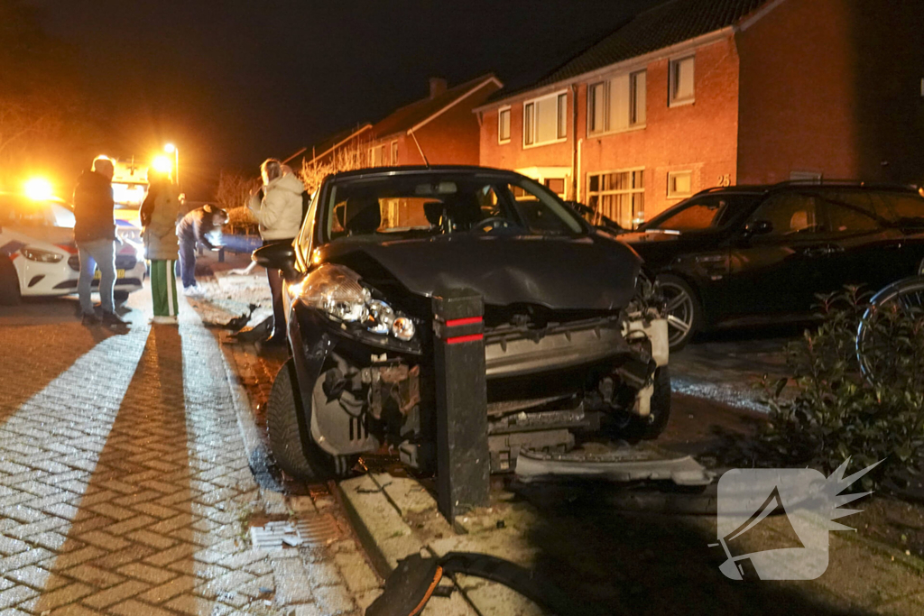 Automobilist ramt lantaarnpaal en kleine paal