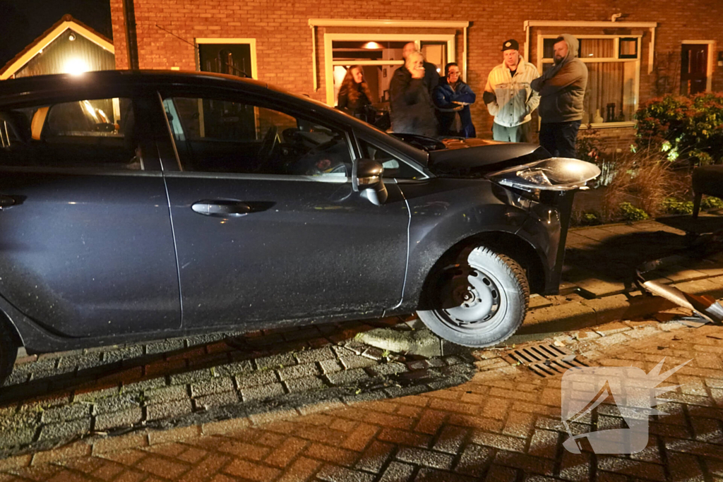 Automobilist ramt lantaarnpaal en kleine paal