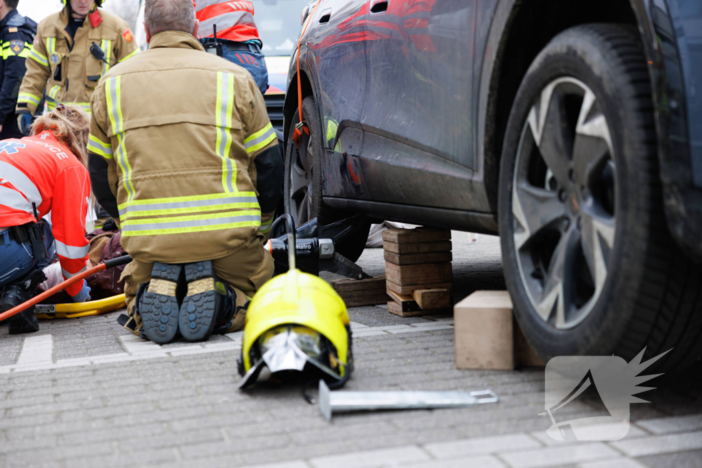 Fietsster bekneld onder auto na aanrijding