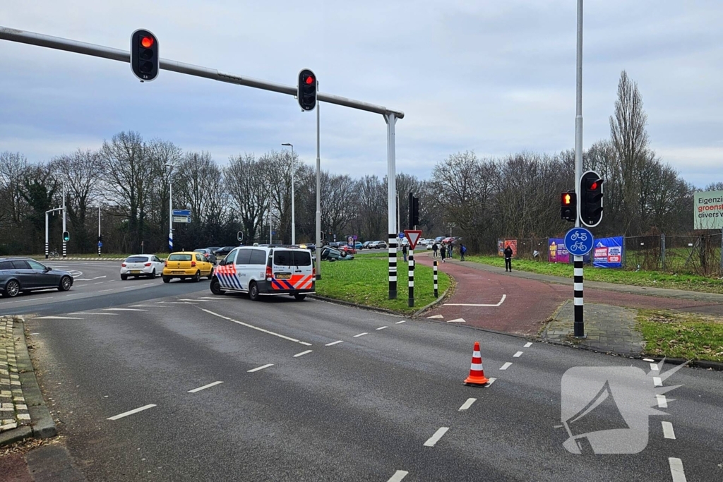 Auto belandt op kop naast rotonde