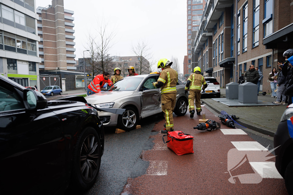 Vrouw bekneld na botsing tussen twee auto's